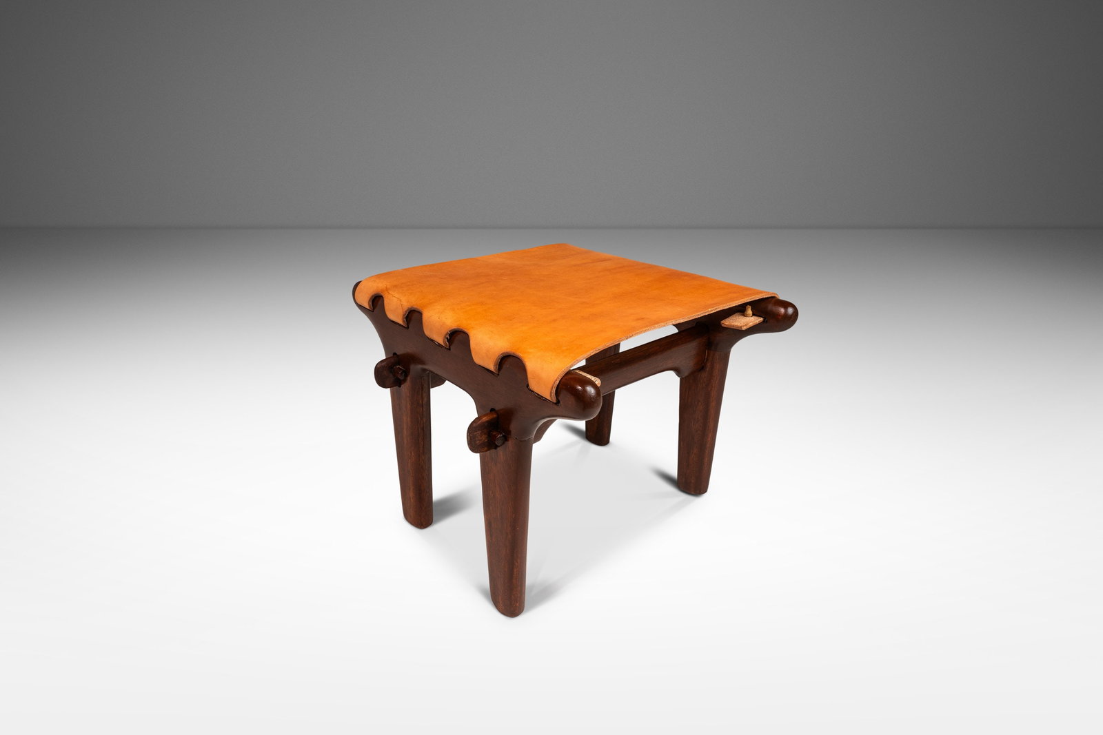 Angel Pazmino 1960s Mid-Century Modern Tooled Leather Sling Ottoman Ecuador: Angel Pazmino 1960s Mid-Century Modern Tooled Leather Sling Ottoman Ecuador Discover the captivating Mid-Century Modern Tooled Leather Sling Ottoman / Footstool designed by the renowned Angel Pazmino,