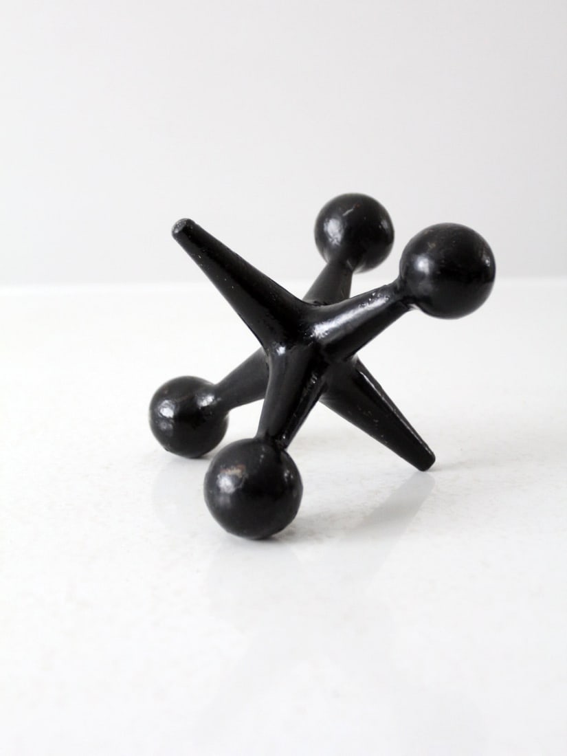 Mid Century Black Finish Cast Iron Jack Sculpture: Mid Century Black Finish Cast Iron Jack Sculpture This mid 20th century cast iron jack sculpture is an excellent decorative piece that adds a modern touch to any desk or shelf. It serves a dual purpos