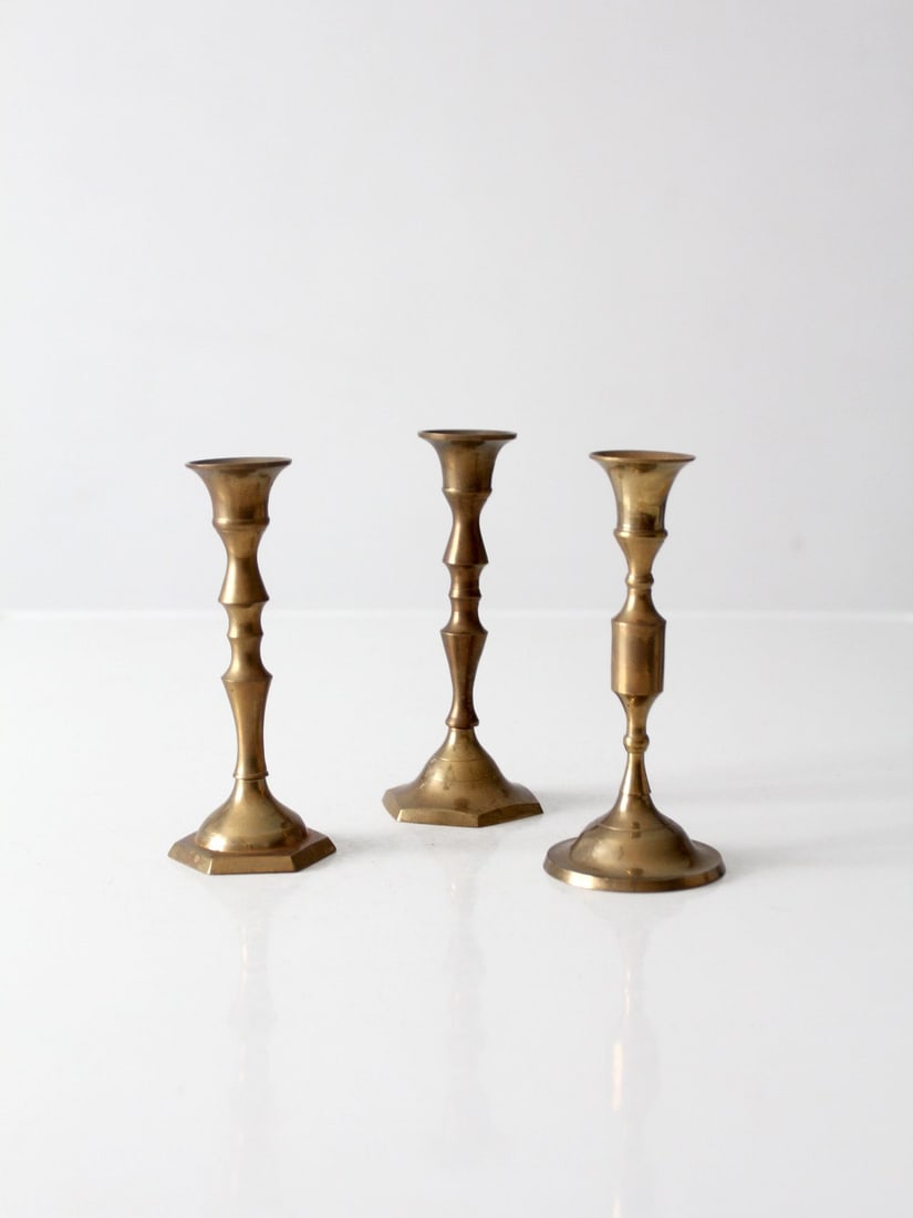 Set of 3 Mid Century Brass Taper Candle Holders: Set of 3 Mid Century Brass Taper Candle Holders Set of three vintage brass candlesticks with varied turned forms and a warm aged patina. Each piece has a slightly different profile and base shape, giv