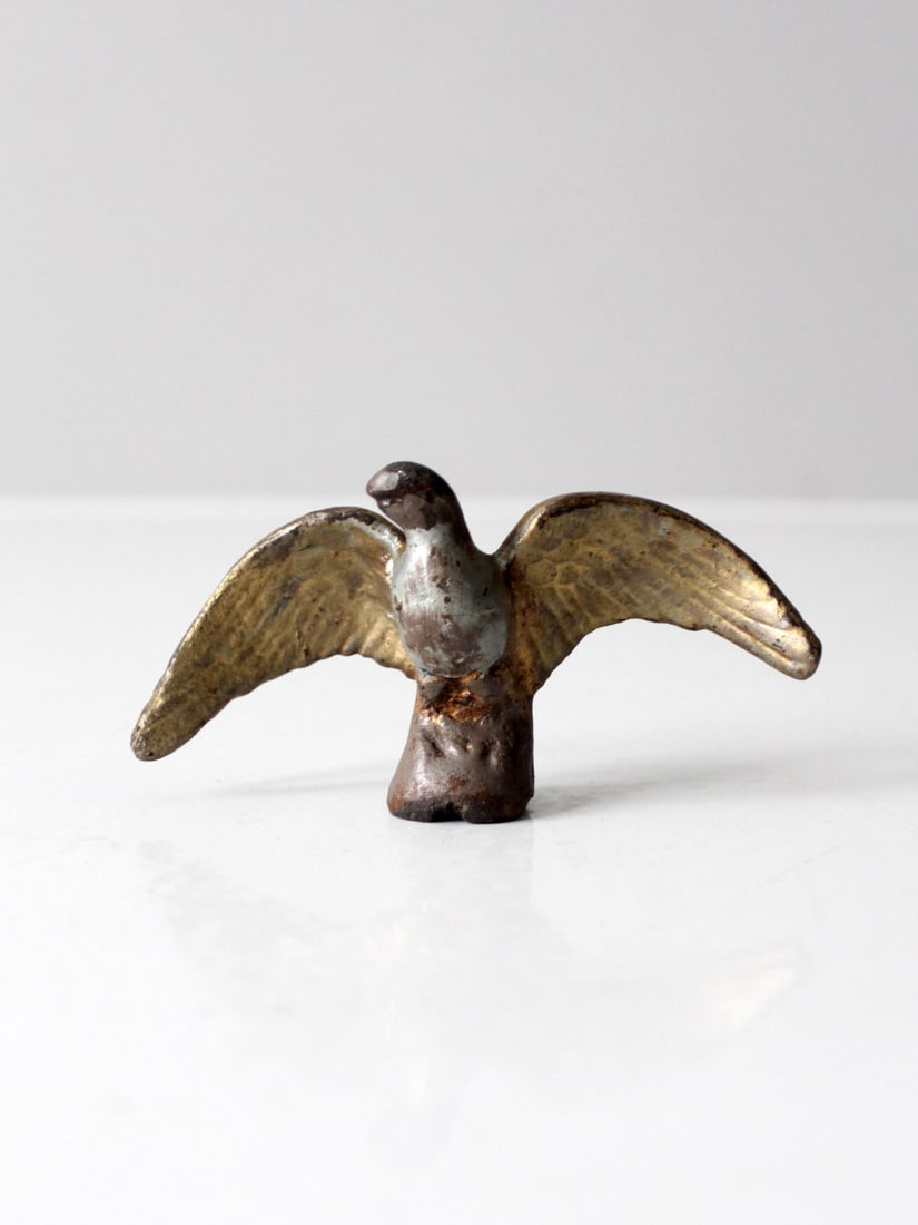 Early 20th Century Gilt Cast Iron Eagle Figurine: Early 20th Century Gilt Cast Iron Eagle Figurine This early 20th century cast iron eagle figurine features a beautiful gilt finish that has developed a rich, mottled patina over time. Its compact form