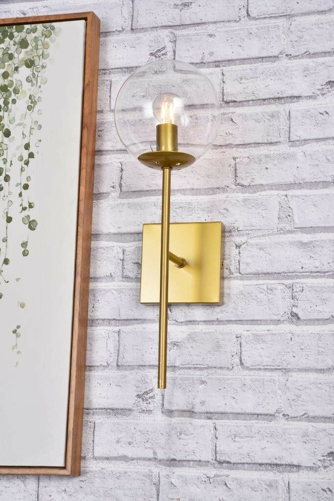 Neri Brass Glass Wall Sconce 1 Light: Neri Brass Glass Wall Sconce 1 Light This modern wall sconce from the Neri Collection features a brass color metal fixture paired with a clear round glass shade. Designed for indoor use, it provides v