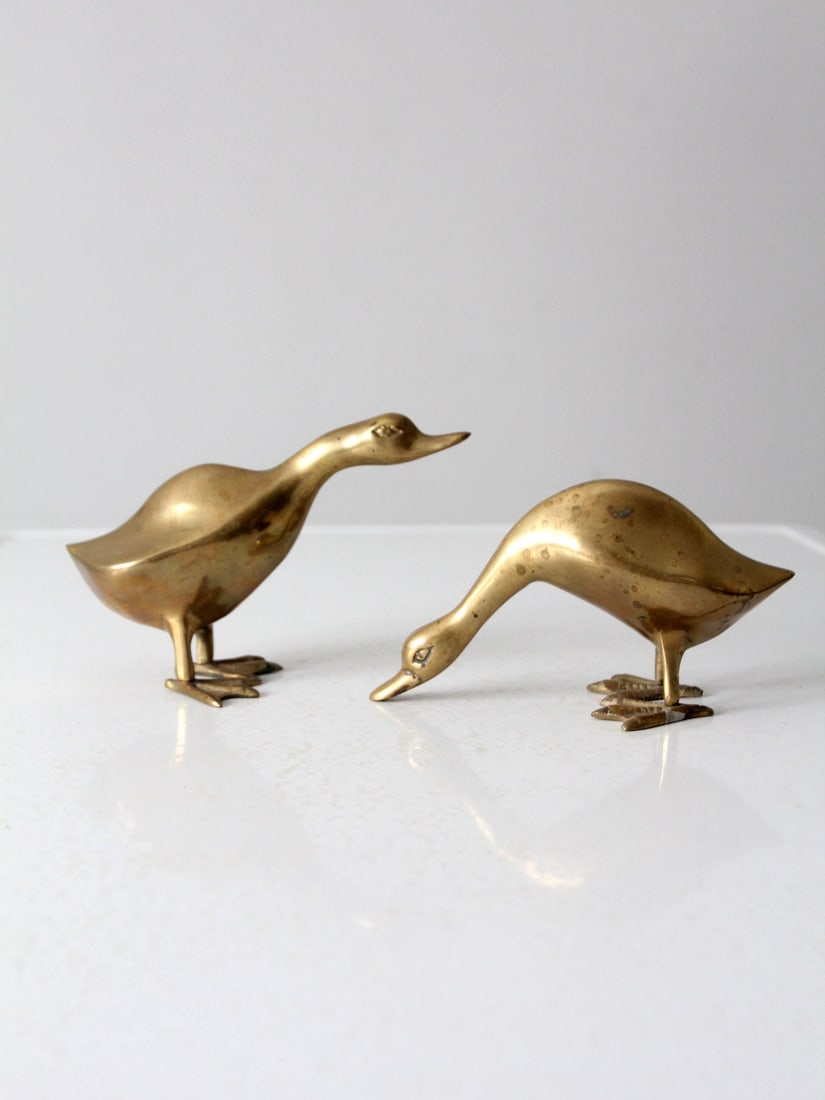 Vintage Mid Century Brass Geese Pair with Elegant Patina: Vintage Mid Century Brass Geese Pair with Elegant Patina This charming pair of mid 20th century vintage brass geese figures showcases sleek modern lines and a beautiful patina, perfect for adding a to