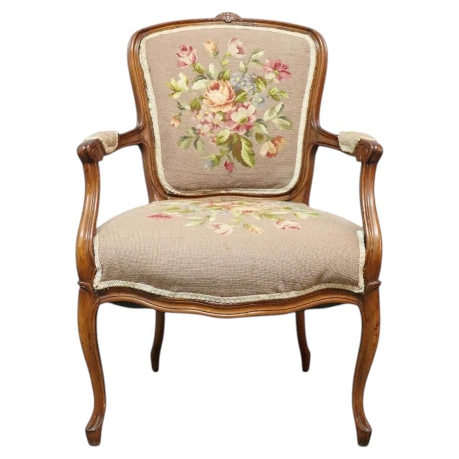 C1900 French Walnut Louis XV Style Armchair with Floral Tapestry: C1900 French Walnut Louis XV Style Armchair with Floral Tapestry Antique French armchair in Louis XV style, dating to circa 1900. Crafted from carved walnut, it features Rococo-inspired curves, a shel
