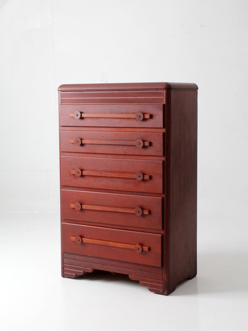 Art Deco five-drawer dresser with waterfall top: Art Deco five-drawer dresser with waterfall top This early 20th century Art Deco dresser features a warm reddish-brown finish and a distinctive architectural silhouette. The design includes a rounded 