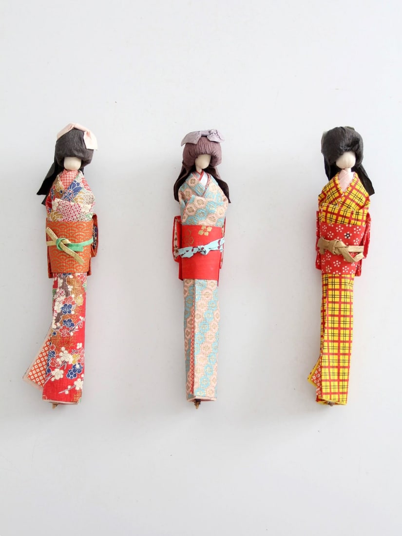 Set of 3 Japanese Folk Art Kimono Dolls: Set of 3 Japanese Folk Art Kimono Dolls This set includes three mid-century Japanese folk art kimono dolls, each featuring vibrant patterned textiles and intricate folded paper details. Every doll is 