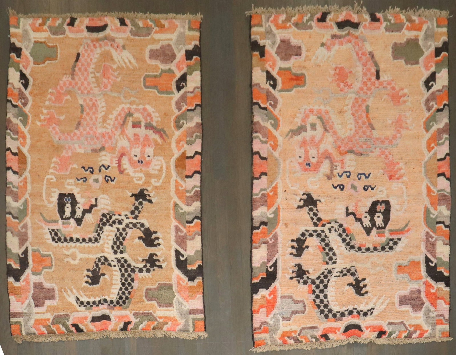 Pair of Early 20th Century Tibetan Dragon Motif Rugs: Pair of Early 20th Century Tibetan Dragon Motif Rugs Pair of early 20th century Tibetan rugs featuring a dragon motif in peach tones. This pictorial pair is offered as a set, and the original descript