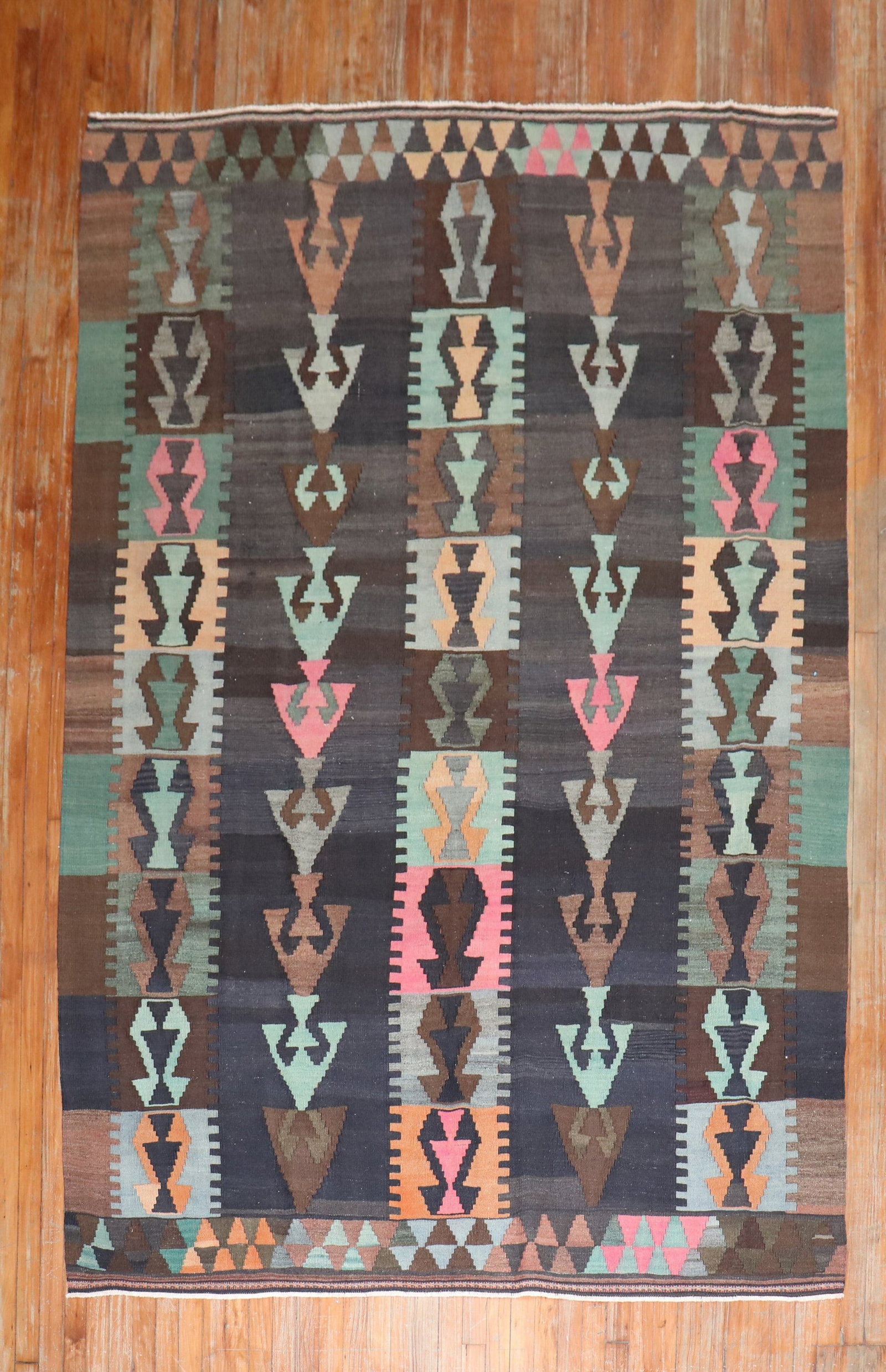 6' 4" x 9' 5" Turkish Kilim Rug Tribal Mid-20th Century: 6' 4" x 9' 5" Turkish Kilim Rug Tribal Mid-20th Century Mid-20th century Turkish Kilim with a tribal flat-weave design and hand knotted construction. The rug features a brown and charcoal background w