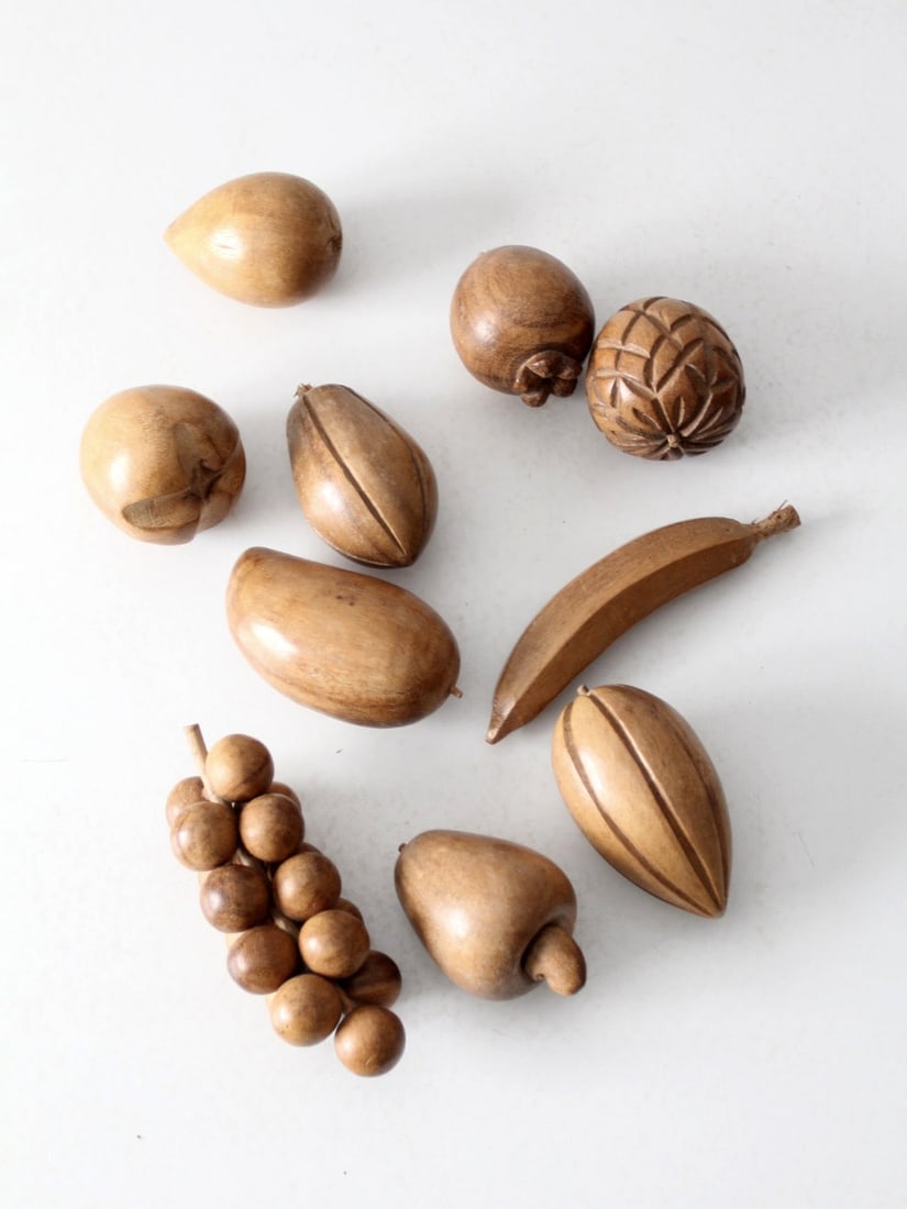 Vintage Mid-Century Monkey Pod Wood Fruit Set of 10: Vintage Mid-Century Monkey Pod Wood Fruit Set of 10 This vintage set of 10 carved monkey pod wood fruits adds warm, natural character to any space. The collection features a sculptural banana, a bunch