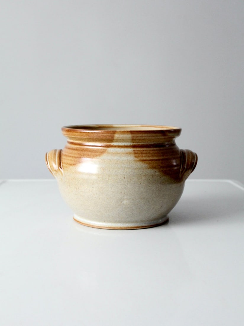 Stoneware cachepot with loop handles 6 inch tall: Stoneware cachepot with loop handles 6 inch tall This vintage studio pottery cachepot features warm stoneware with a brown glaze over a lighter base. Designed with a rounded body and small loop handle