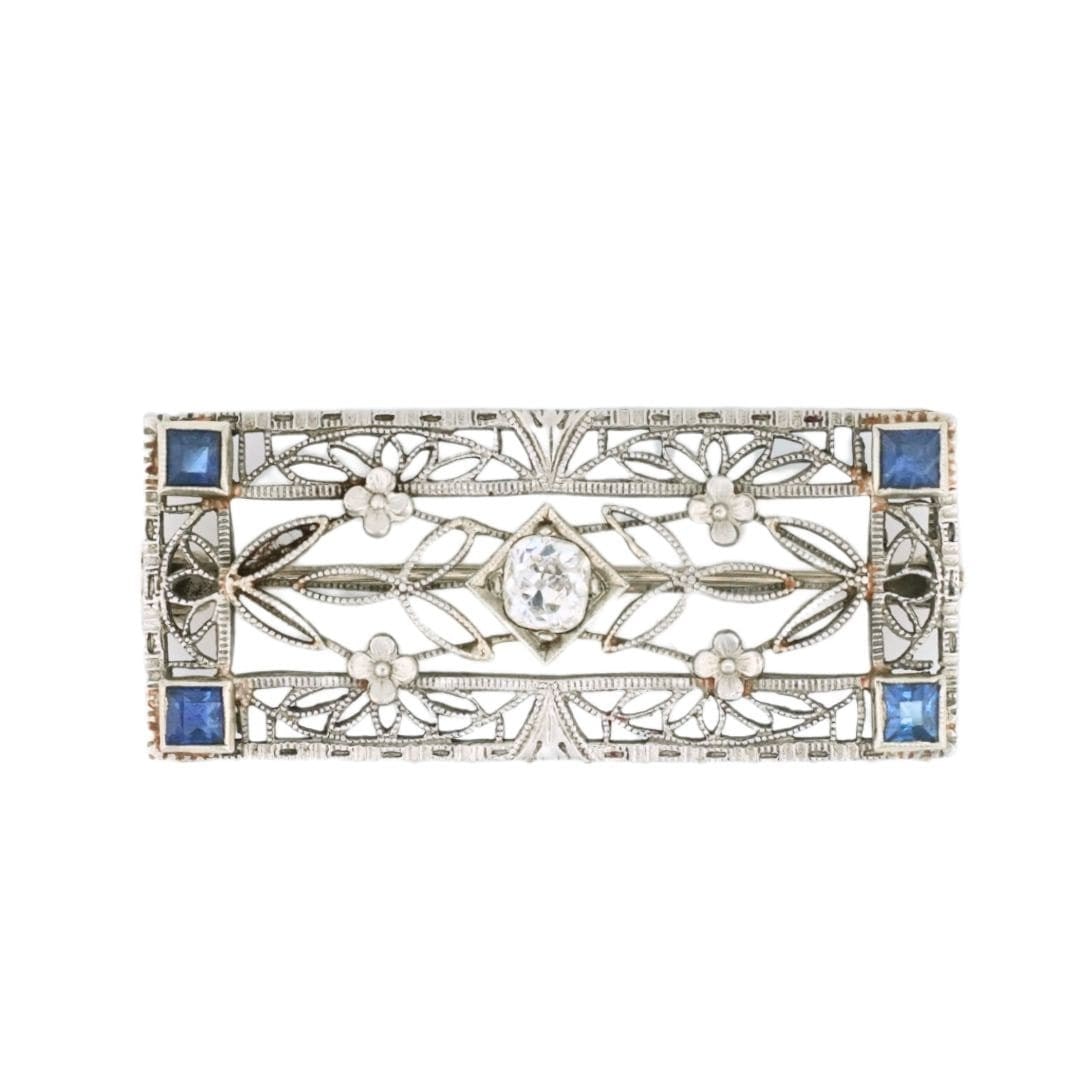 Art Deco filigree brooch in 14K white gold with diamond and blue spinel: Art Deco filigree brooch in 14K white gold with diamond and blue spinel Antique Art Deco filigree brooch crafted in 14K white gold and set with a natural old mine cut diamond at the center, accented b
