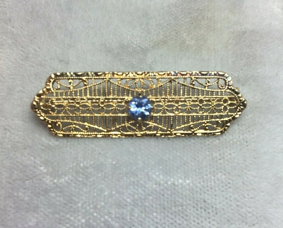 Art Deco 10k Yellow Gold Filigree Sapphire Pin 0.27ct: Art Deco 10k Yellow Gold Filigree Sapphire Pin 0.27ct This exquisite Art Deco pin is crafted from 10k yellow gold and features a stunning genuine natural sapphire. The pin measures approximately 1 3/8