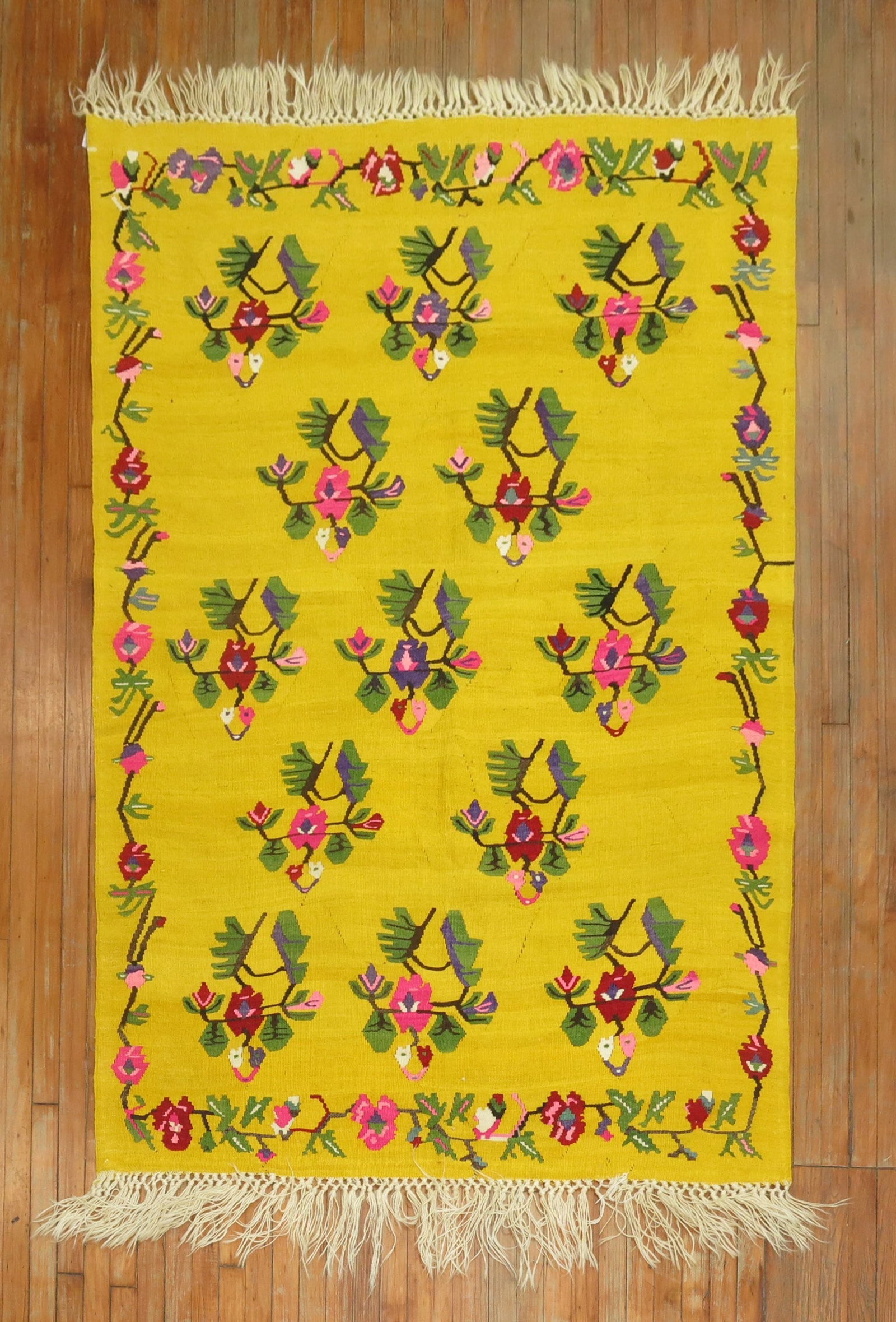 4' 11" x 7' 3" Floral Turkish Kilim Rug in Yellow: 4' 11" x 7' 3" Floral Turkish Kilim Rug in Yellow Vintage Turkish kilim with a bright yellow field and floral pattern. This pre-owned woven rug features a decorative border and fringe finish. Specific