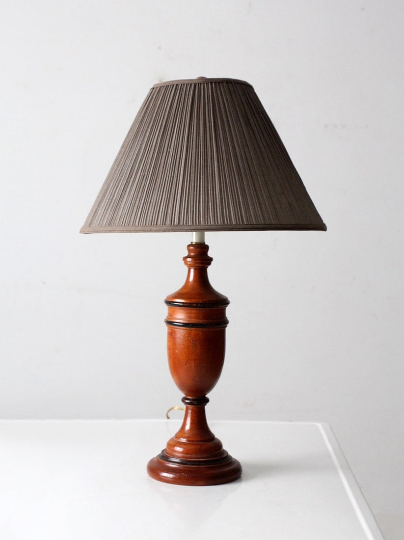 Vintage American Turned Wood Table Lamp with Pleated Gray Shade: Vintage American Turned Wood Table Lamp with Pleated Gray Shade This mid-century American table lamp features a finely turned wood base with warm, polished tones and smooth, measured transitions. It i
