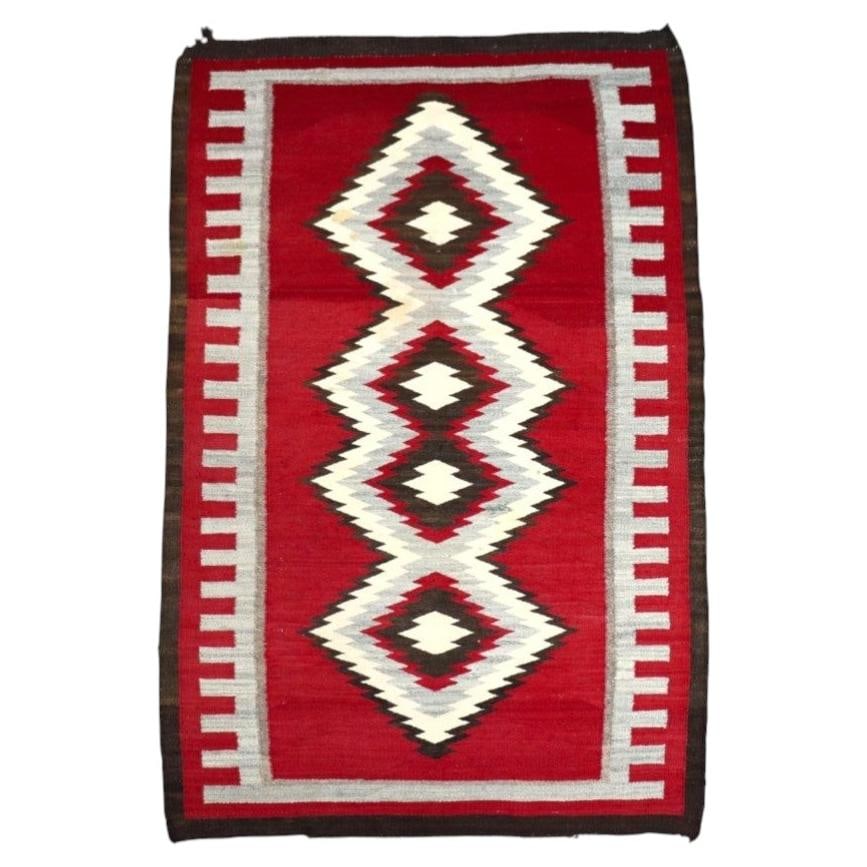 1930s Navajo wool Eye Dazzler rug 40.25 x 61.25 in: 1930s Navajo wool Eye Dazzler rug 40.25 x 61.25 in This antique Native American Navajo Eye Dazzler rug, dating to around 1930, is hand-woven from natural wool fibers. It features a vibrant geometric d