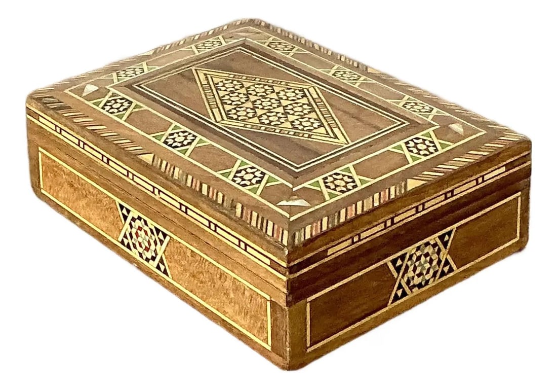Moroccan wood and mother of pearl lidded chest: Moroccan wood and mother of pearl lidded chest This vintage Moroccan inlay box exemplifies traditional craftsmanship with its intricate wood marquetry and geometric mosaic design. Each surface is meti
