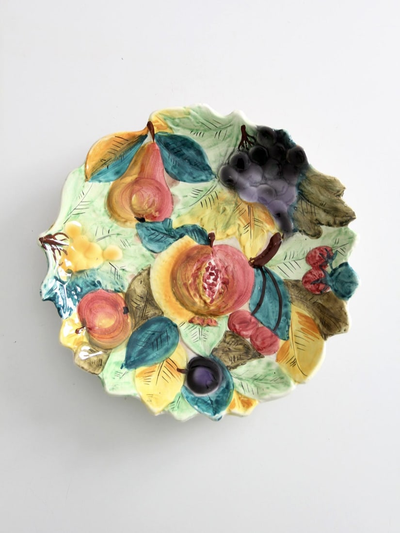 Mid-Century Italian Majolica Plate with Raised Fruit Design: Mid-Century Italian Majolica Plate with Raised Fruit Design This vintage Italian majolica plate features a mid-century design with raised fruit and foliage across a gently scalloped form. The hand-pai