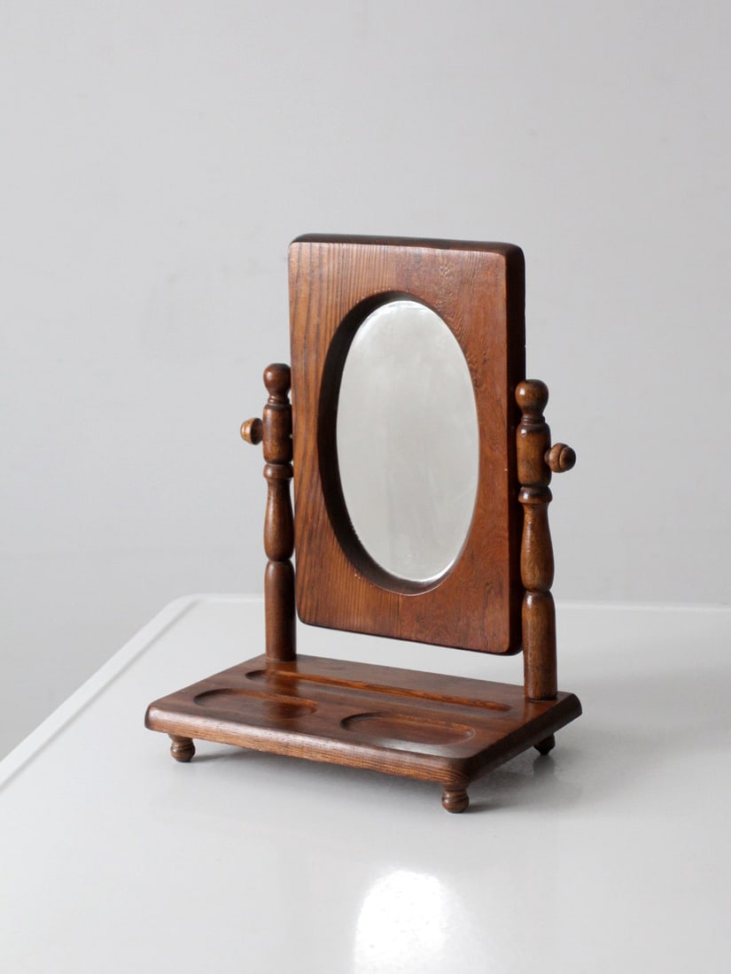 Arts and Crafts Era Wooden Tilting Vanity Mirror with Carved Base: Arts and Crafts Era Wooden Tilting Vanity Mirror with Carved Base This early 20th century wooden vanity mirror showcases Arts and Crafts influence with a tilting oval mirror set in a warm wood frame s