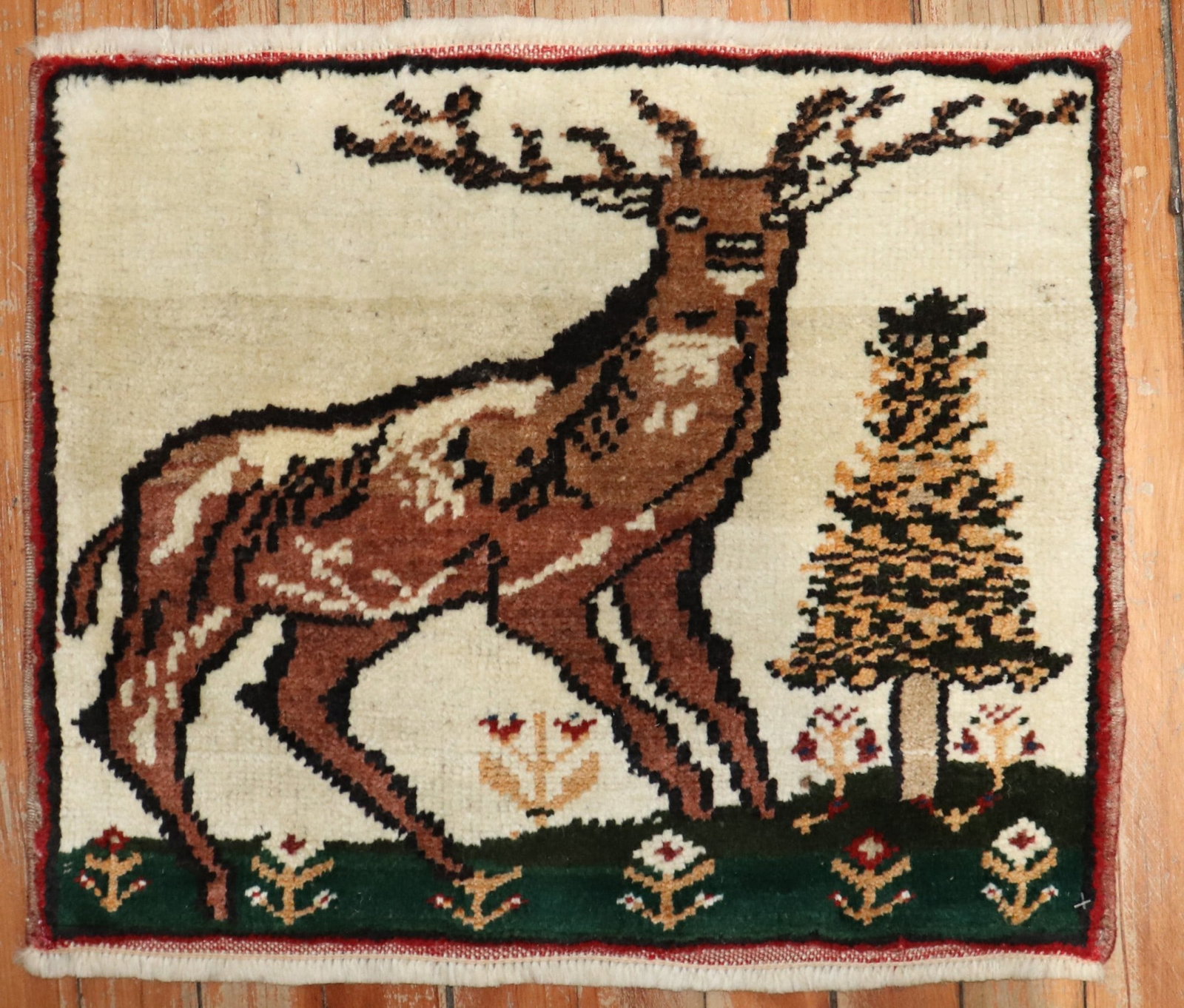 Anatolian pictorial yastik rug with deer 1' 4" x 1' 8": Anatolian pictorial yastik rug with deer 1' 4" x 1' 8" Vintage mid-20th century Turkish mini rug with a pictorial deer design. This pre-owned Anatolian yastik offers a compact square format and distin