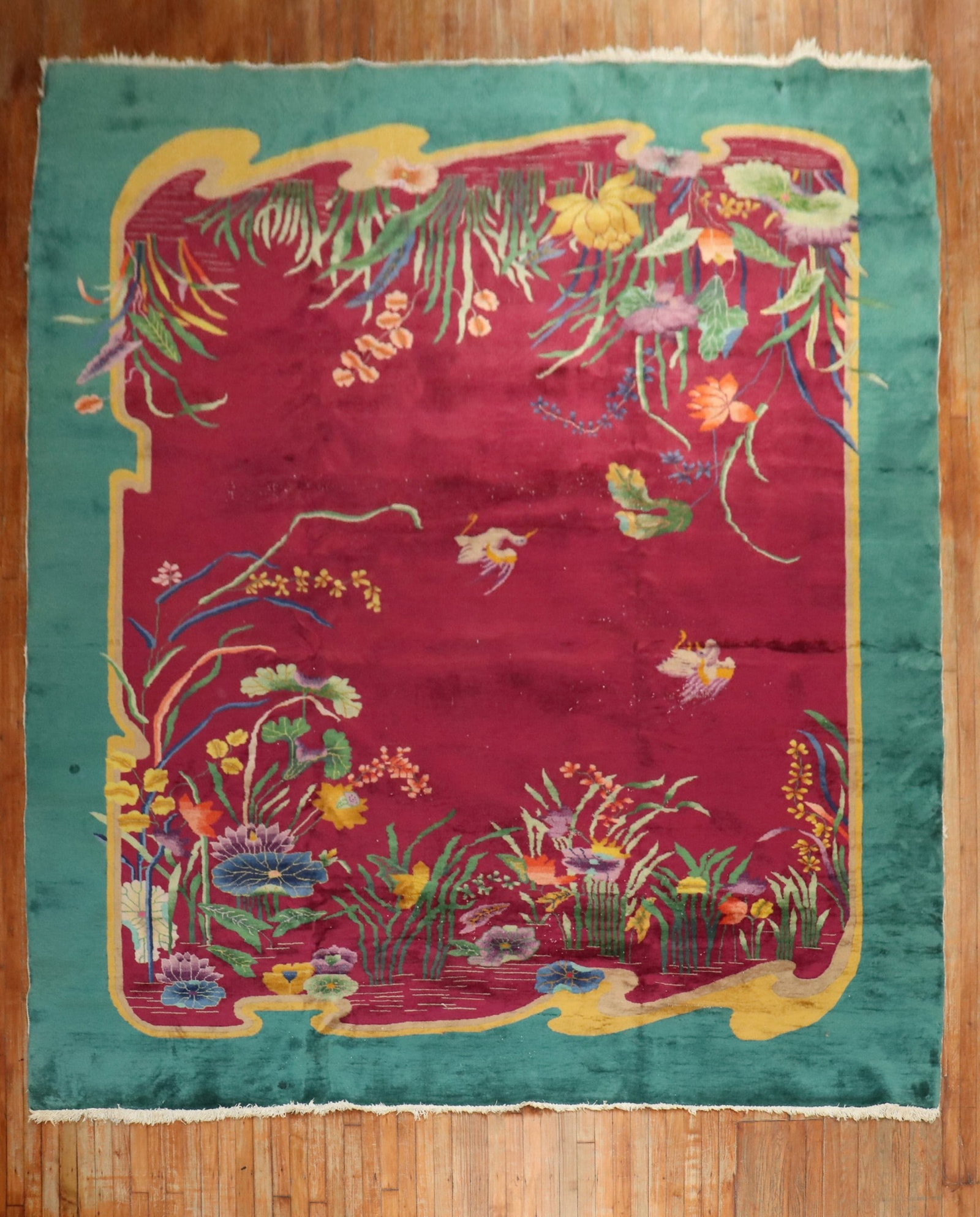 9' 10" x 13' 5" Chinese Deco Nichols Room Rug: 9' 10" x 13' 5" Chinese Deco Nichols Room Rug Chinese Art Deco Nichols rug from the 1930s featuring a floral motif on a burgundy ground with an emerald green border. This pre-owned room-size rug offer