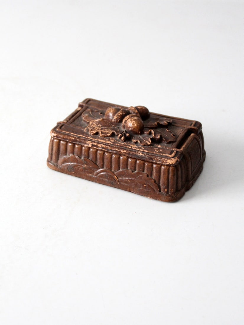 1940s Syroco Wood Cigarette Box with Acorn Motif: 1940s Syroco Wood Cigarette Box with Acorn Motif This vintage 1940s Syroco wood cigarette box features a raised acorn motif on the lid with geometric detailing along the sides. The cast wood composite