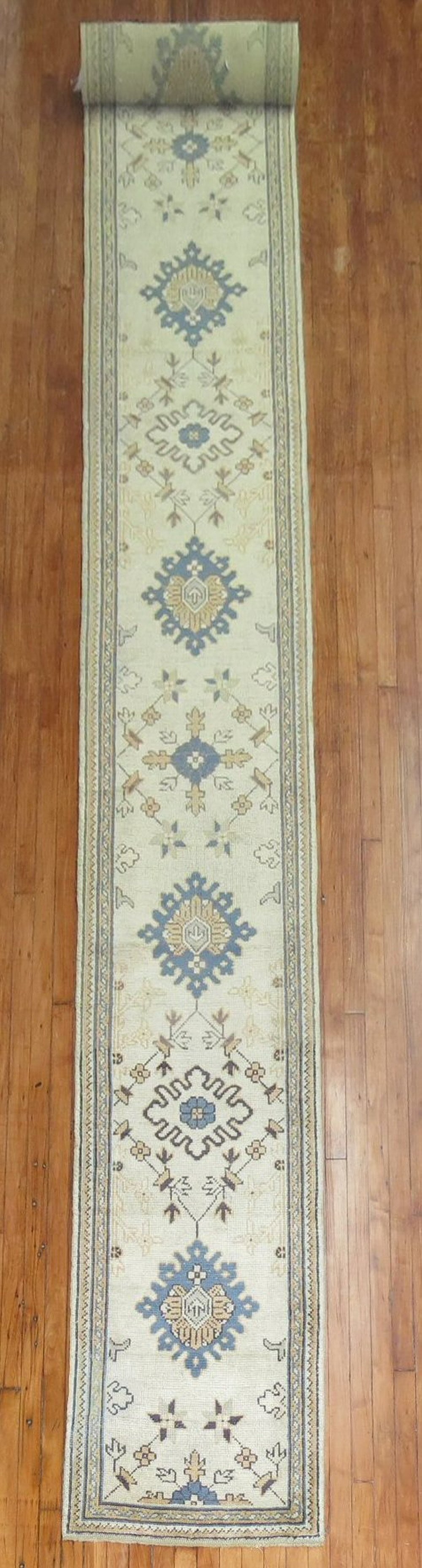 2' 3" x 22' 4" Antique Turkish Oushak Runner Ivory Field: 2' 3" x 22' 4" Antique Turkish Oushak Runner Ivory Field Antique Turkish Oushak runner from the early 20th century with an ivory field and a long, narrow profile. This pre-owned runner is categorized 