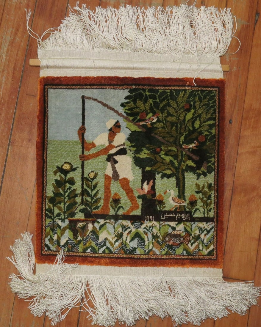 Square Persian silk pictorial rug signed and dated 1991: Square Persian silk pictorial rug signed and dated 1991 Pre-owned silk Persian pictorial rug featuring a man holding a stick with two birds hanging on it, with a duck behind. This square yastik is sig