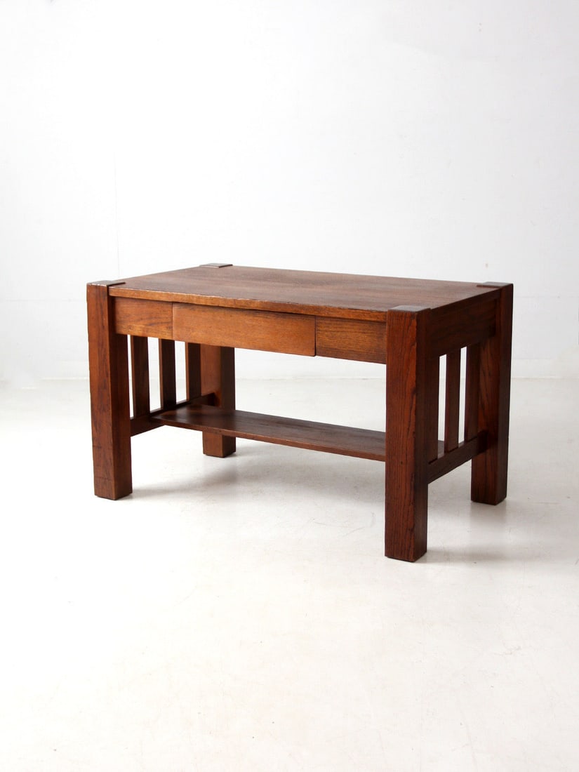 Vintage Mission Style Solid Oak Desk with Center Drawer: Vintage Mission Style Solid Oak Desk with Center Drawer This vintage Mission-style oak desk showcases a classic Craftsman design, featuring slatted wood sides and a convenient center drawer for storag