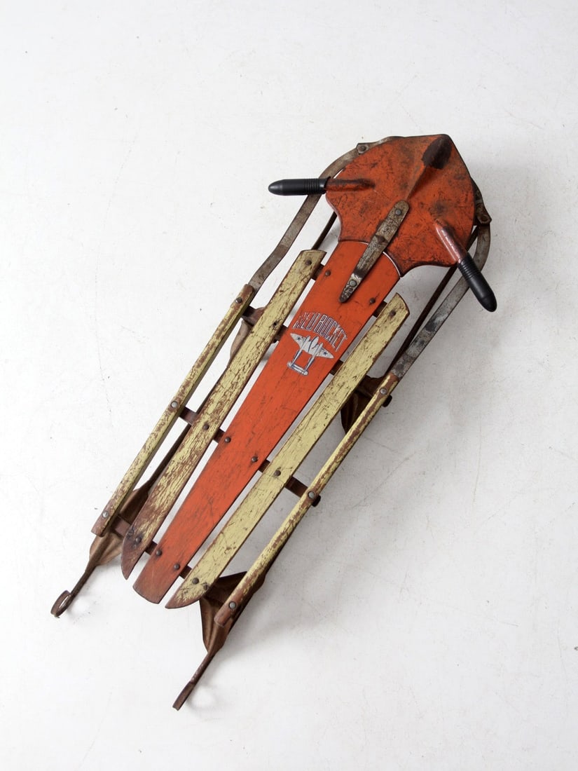 Vintage Mid-Century Red Rocket Sled in Orange and Yellow: Vintage Mid-Century Red Rocket Sled in Orange and Yellow This charming mid-century Red Rocket sled features bright orange and pale yellow tones, creating a nostalgic accent perfect for porches, firepl