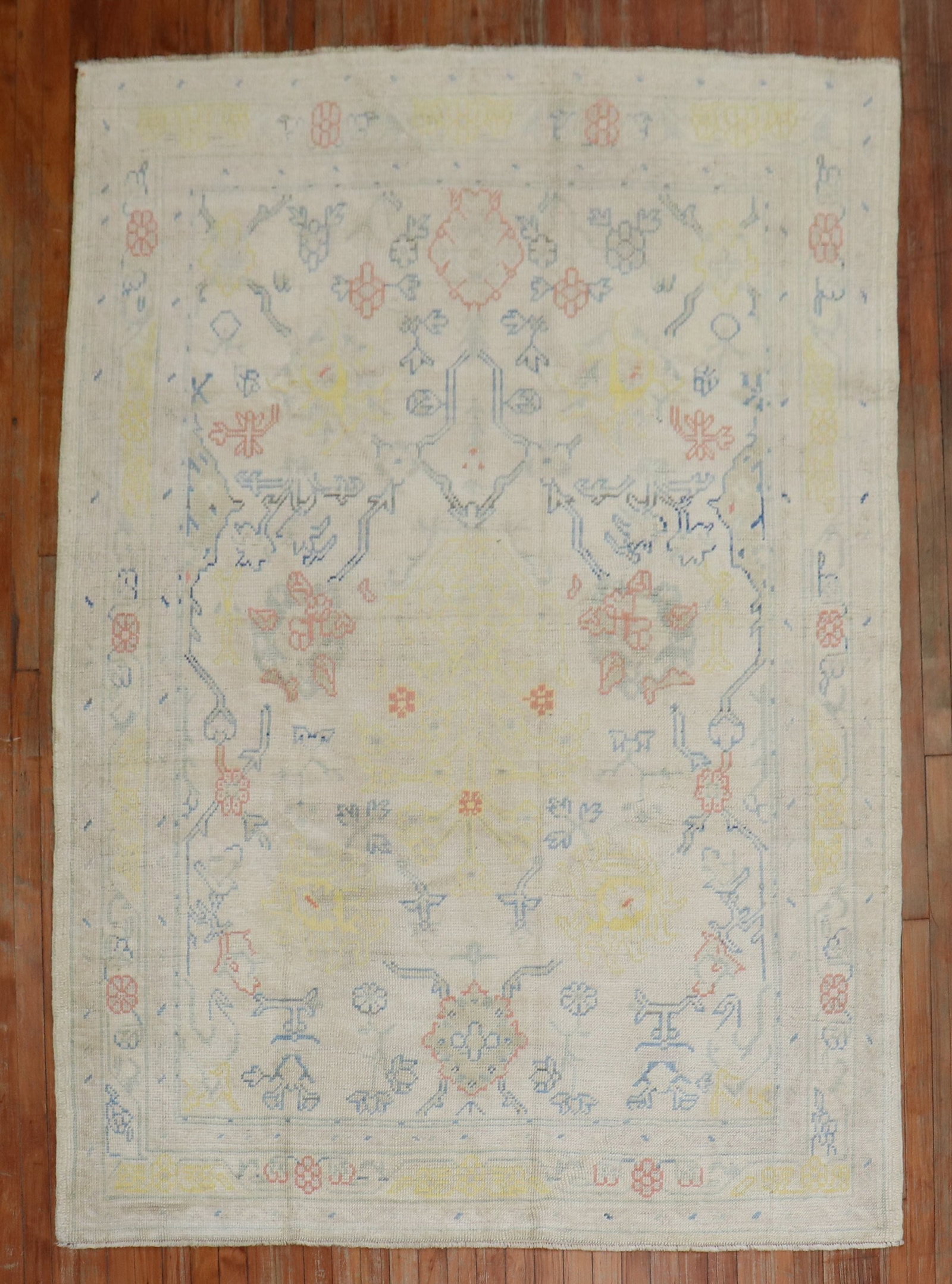 5' 8" x 7' 8" Antique Oushak Accent Rug Ivory Field: 5' 8" x 7' 8" Antique Oushak Accent Rug Ivory Field Pre-owned antique Oushak accent rug featuring blue, yellow, and orange accents on an ivory field. Specifications Type: Oushak Category: Intermediate