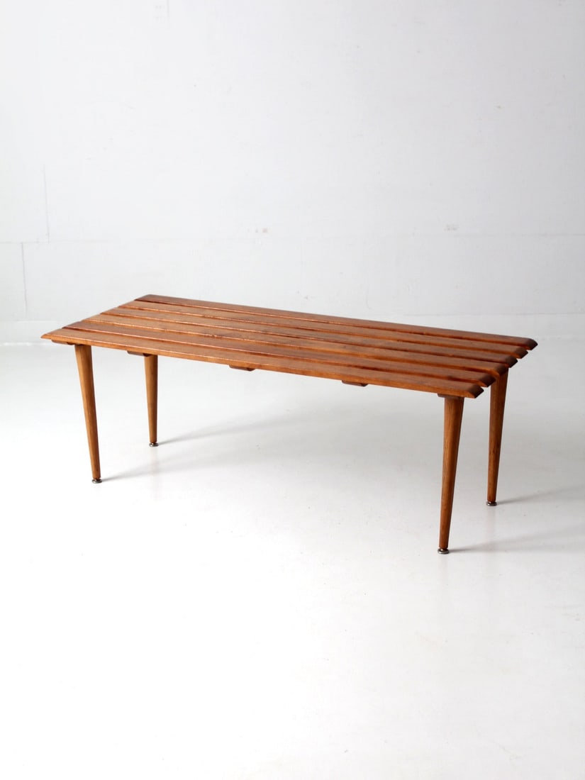 Mid Century Slat Wood Coffee Table Vintage Design 48in: Mid Century Slat Wood Coffee Table Vintage Design 48in This elegant Mid Century Slat Wood Bench serves as a versatile coffee table, showcasing a stylish slat top and sleek tapered legs. Its vintage de
