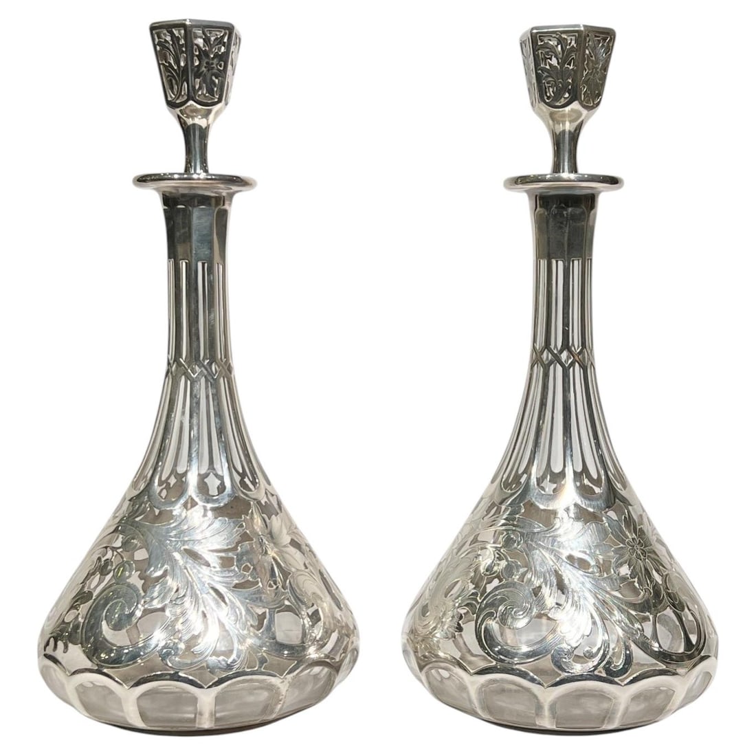 Set of 2 Art Nouveau Glass Wine Decanters with Silver Overlay: Set of 2 Art Nouveau Glass Wine Decanters with Silver Overlay Pair of antique Art Nouveau wine decanters featuring glass bodies with silver overlay decoration of flowers and foliage. Dating to the lat