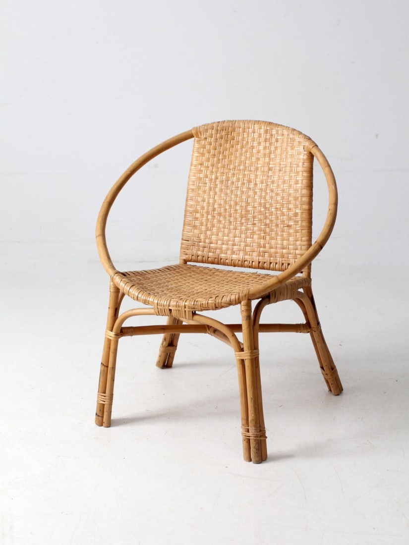 Vintage Mid-Century Rattan Lounge Chair with Sculptural Design: Vintage Mid-Century Rattan Lounge Chair with Sculptural Design This mid-century rattan chair showcases a sculptural circular frame paired with a beautifully woven seat and back. The design incorporate