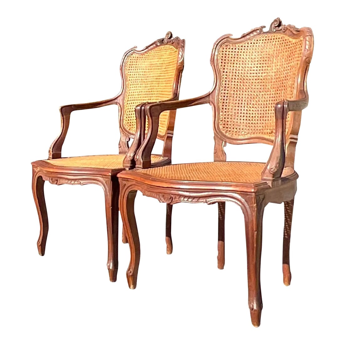 Vintage Boho Walnut Cane Arm Chairs - Pair from Palm Beach: Vintage Boho Walnut Cane Arm Chairs - Pair from Palm Beach This stunning pair of vintage Boho arm chairs features exquisite hand-carved detailing complemented by elegant inset cane panels. Crafted fro