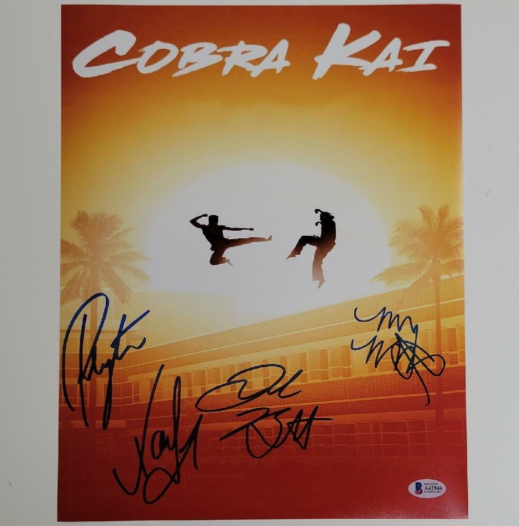 11x14 Photo Signed by Four Cobra Kai Cast Members Beckett Authenticated: 11x14 Photo Signed by Four Cobra Kai Cast Members Beckett Authenticated This is an original 11x14 inch photograph signed by four members of the Cobra Kai cast, including List, Mouser, and Bertrand. Th