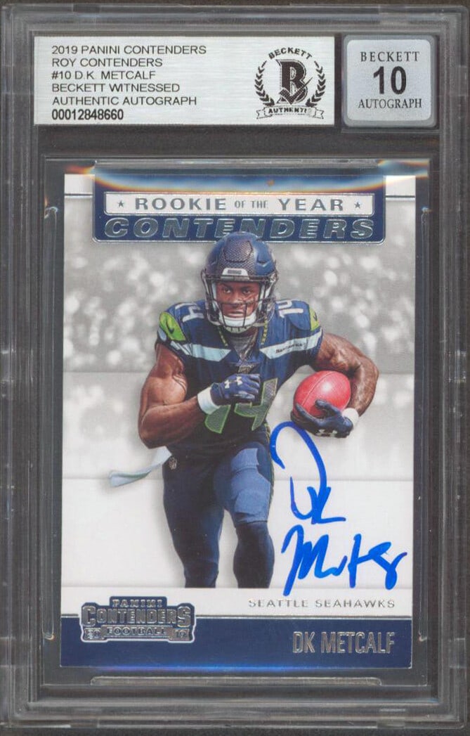 D.K. Metcalf Autographed 2019 ROY Contenders Rookie Card Beckett 10 Graded Slab: D.K. Metcalf Autographed 2019 ROY Contenders Rookie Card Beckett 10 Graded Slab This 2019 Panini Contenders ROY Contenders #10 rookie card features D.K. Metcalf of the Seattle Seahawks. The card has b
