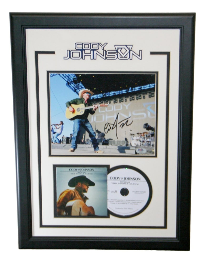 Framed 10x8 signed Cody Johnson photo with CD cover PSA DNA: Framed 10x8 signed Cody Johnson photo with CD cover PSA DNA Framed 10x8 photo autographed by Cody Johnson, accompanied by a CD and cover. This original country music collectible is authenticated by PS