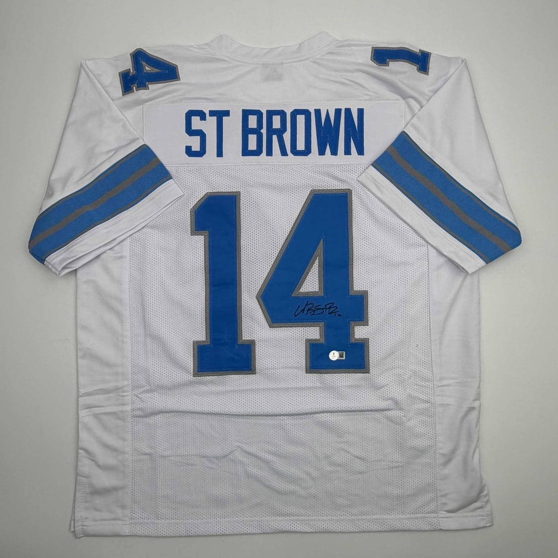 Beckett BAS Certified Amon-Ra St. Brown Signed Detroit Lions White Jersey: Beckett BAS Certified Amon-Ra St. Brown Signed Detroit Lions White Jersey Autographed white custom football jersey signed by Amon-Ra St. Brown. This pre-owned collectible features the player's name an