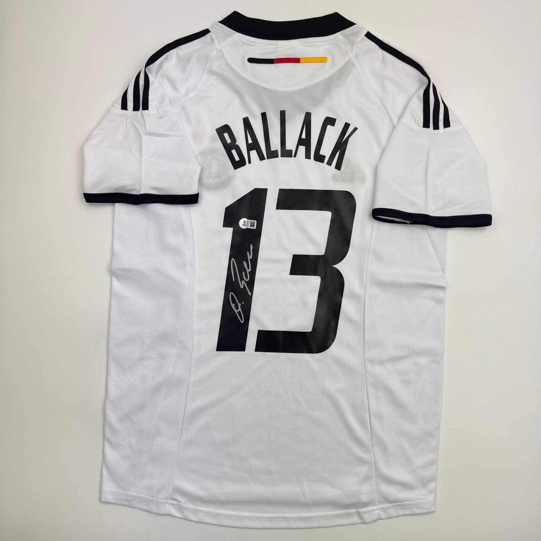 Michael Ballack Signed Germany Jersey with Beckett BAS COA: Michael Ballack Signed Germany Jersey with Beckett BAS COA Celebrate the legacy of Michael Ballack with this autographed Germany white jersey. Authenticated by Beckett Grading Services, this original 