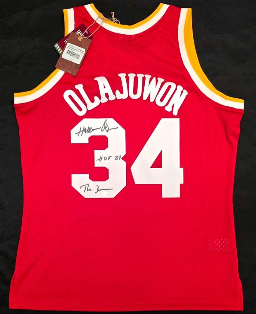 Houston Rockets Mitchell Ness Jersey signed by Hakeem Olajuwon Fanatics: Houston Rockets Mitchell Ness Jersey signed by Hakeem Olajuwon Fanatics Pre-owned Mitchell Ness Houston Rockets basketball jersey signed by Hakeem Olajuwon and inscribed "HOF 08, The Dream." This is a