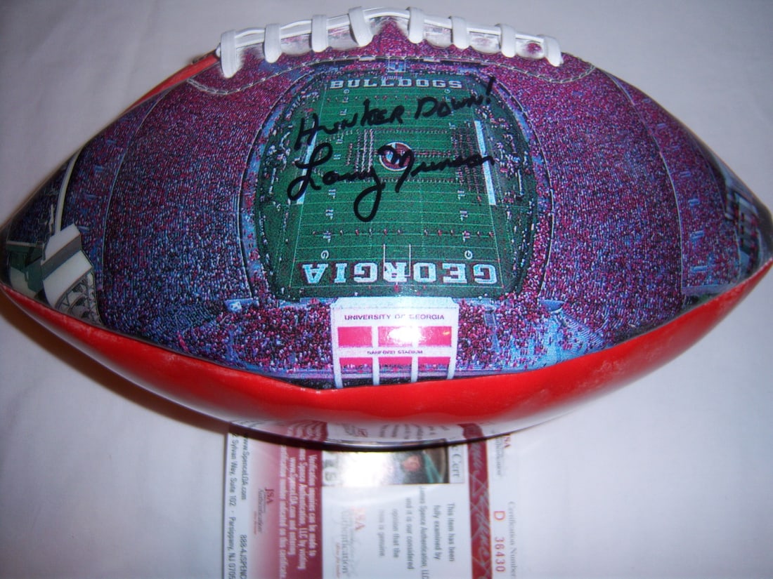 Autographed Georgia Bulldogs Football Signed by Larry Munson with JSA COA: Autographed Georgia Bulldogs Football Signed by Larry Munson with JSA COA This is a pre-owned football signed by Larry Munson, the legendary voice of the Georgia Bulldogs, featuring the phrase "Hunker