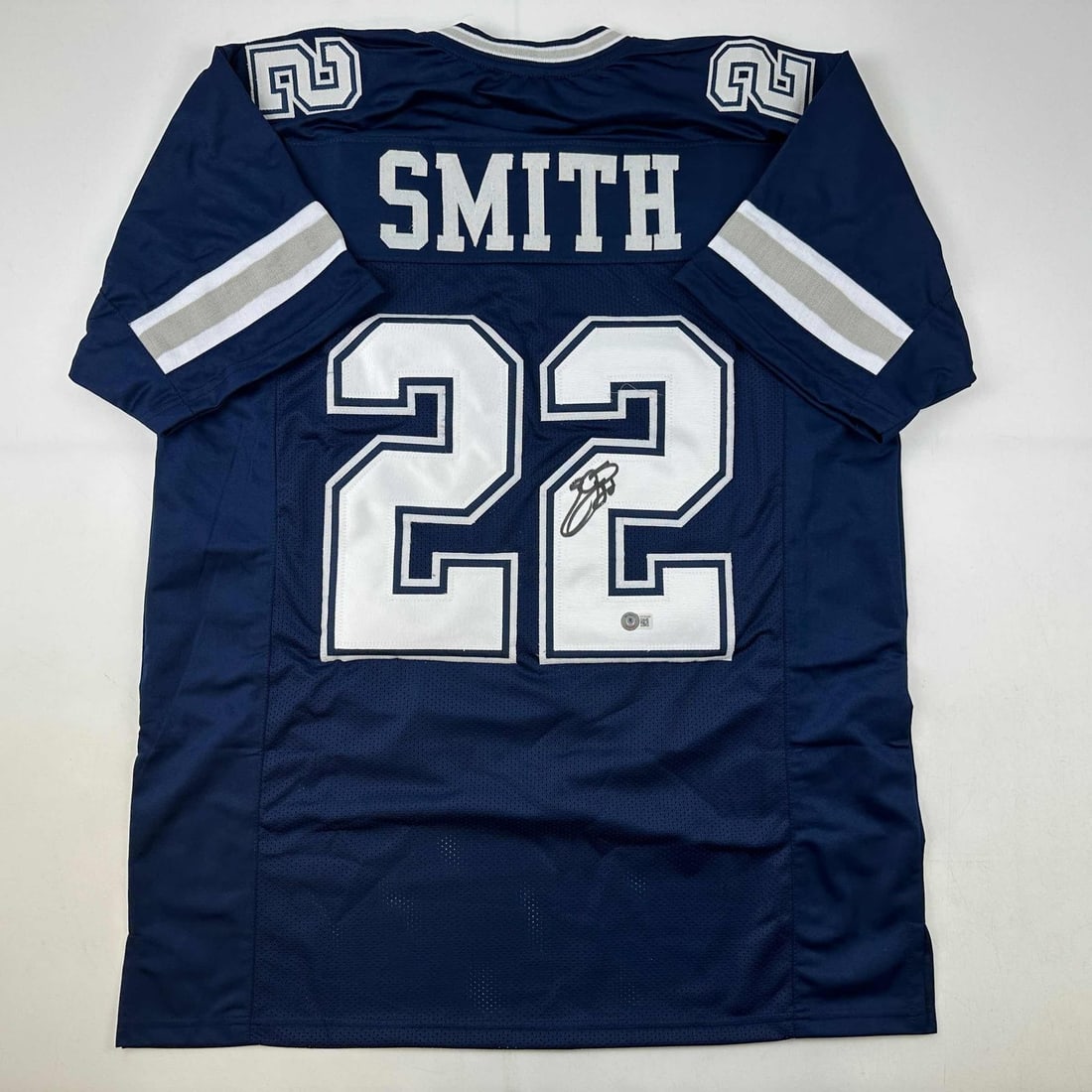 Beckett BAS Certified Emmitt Smith Signed Blue Custom Football Jersey: Beckett BAS Certified Emmitt Smith Signed Blue Custom Football Jersey Autographed Emmitt Smith custom blue football jersey intended as a collectible. The jersey displays the player's name and number a