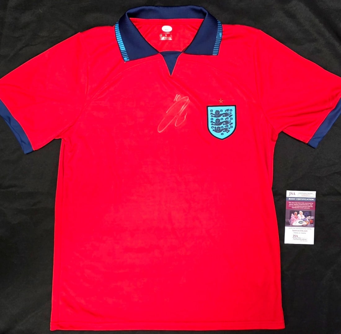 Jude Bellingham England Jersey Signed with JSA COA: Jude Bellingham England Jersey Signed with JSA COA This is an original signed England jersey featuring the autograph of soccer star Jude Bellingham, who currently plays for Real Madrid. The jersey com