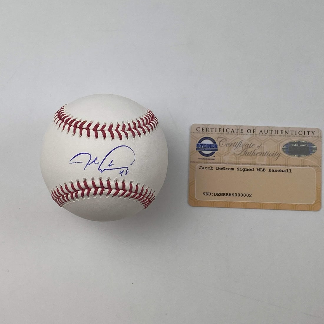 Jacob DeGrom signed Rawlings ROML baseball with Steiner COA: Jacob DeGrom signed Rawlings ROML baseball with Steiner COA Official Rawlings ROML baseball signed by Jacob DeGrom. This original autographed baseball is accompanied by a Steiner COA and is graded GM 