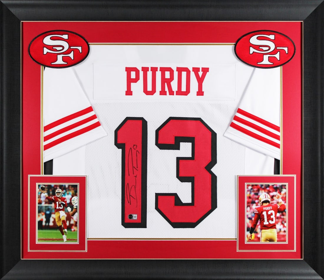 Framed White Pro Style Jersey Signed by Brock Purdy BAS Witnessed: Framed White Pro Style Jersey Signed by Brock Purdy BAS Witnessed This autographed white pro style framed jersey has been personally signed by Brock Purdy of the San Francisco 49ers. It is an original