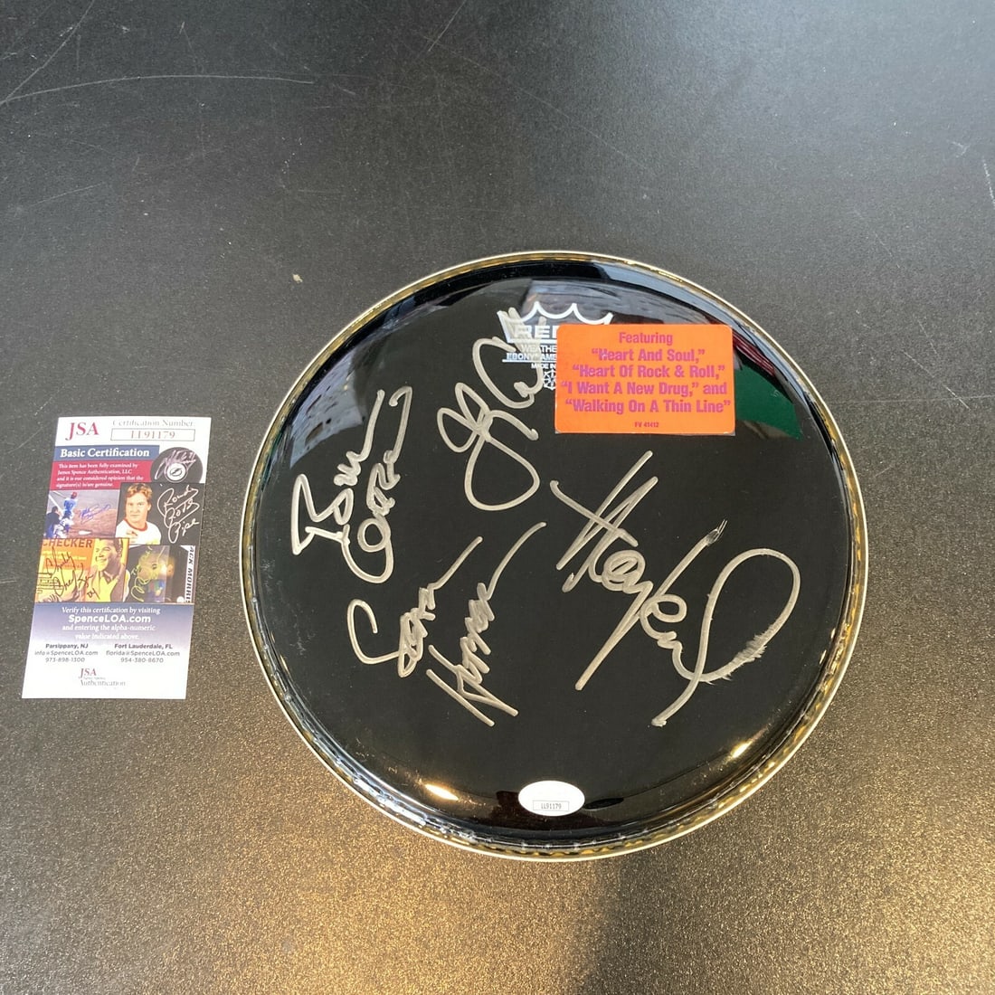 Drumhead Signed by Four Huey Lewis and The News Members with JSA Authentication: Drumhead Signed by Four Huey Lewis and The News Members with JSA Authentication This is an original drumhead autographed by Huey Lewis and The News, featuring four signatures from members of the band.