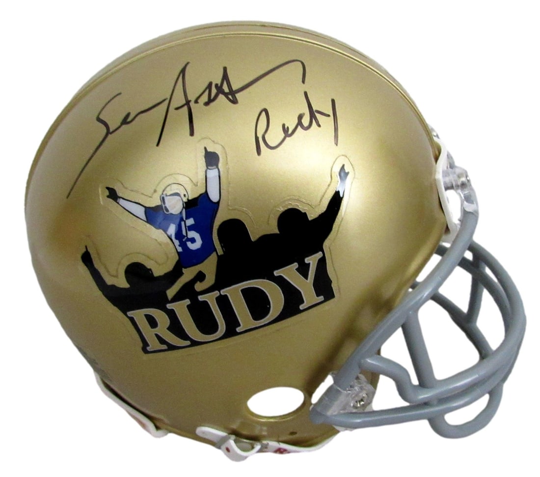 Notre Dame Mini Helmet Signed by Sean Astin and Chelcie Ross JSA Authenticated: Notre Dame Mini Helmet Signed by Sean Astin and Chelcie Ross JSA Authenticated This is a dual-signed and inscribed gold mini football helmet representing Notre Dame from the movie "Rudy." The helmet f