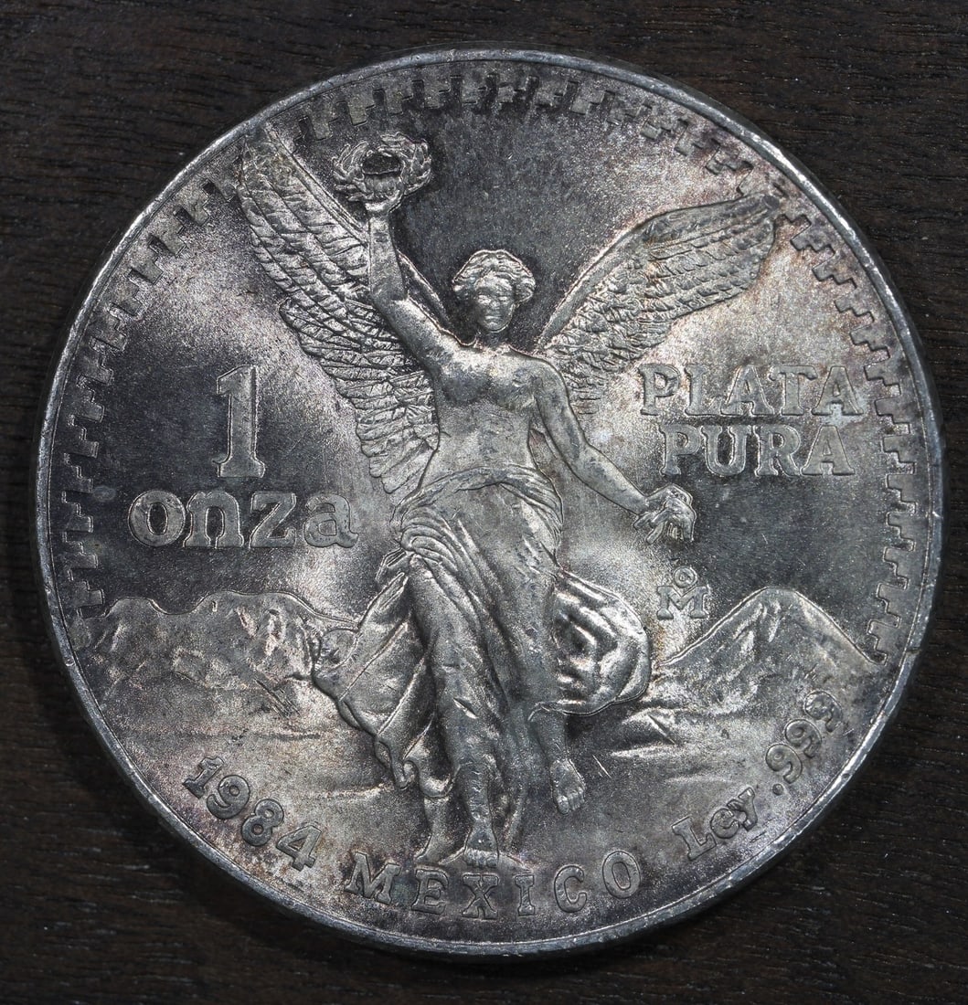 Mexico 1984-Mo Silver Libertad Onza 1 oz .999 Toned Coin: Mexico 1984-Mo Silver Libertad Onza 1 oz .999 Toned Coin 1984-Mo Mexico Silver Libertad Onza coin with toned surfaces. This pre-owned piece is composed of .999 fine silver and contains 1 oz of preciou