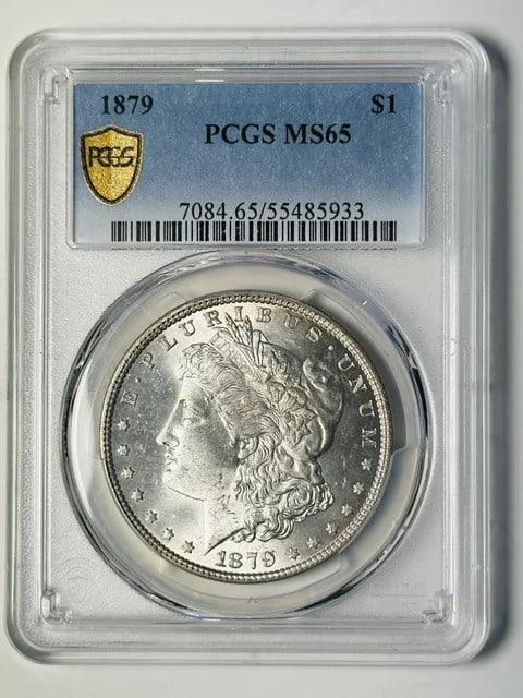 PCGS MS-65 1879 Morgan Silver Dollar Philadelphia White: PCGS MS-65 1879 Morgan Silver Dollar Philadelphia White 1879 Morgan Silver Dollar certified by PCGS and graded MS-65. This pre-owned coin is composed of silver and has a white appearance. Specificatio