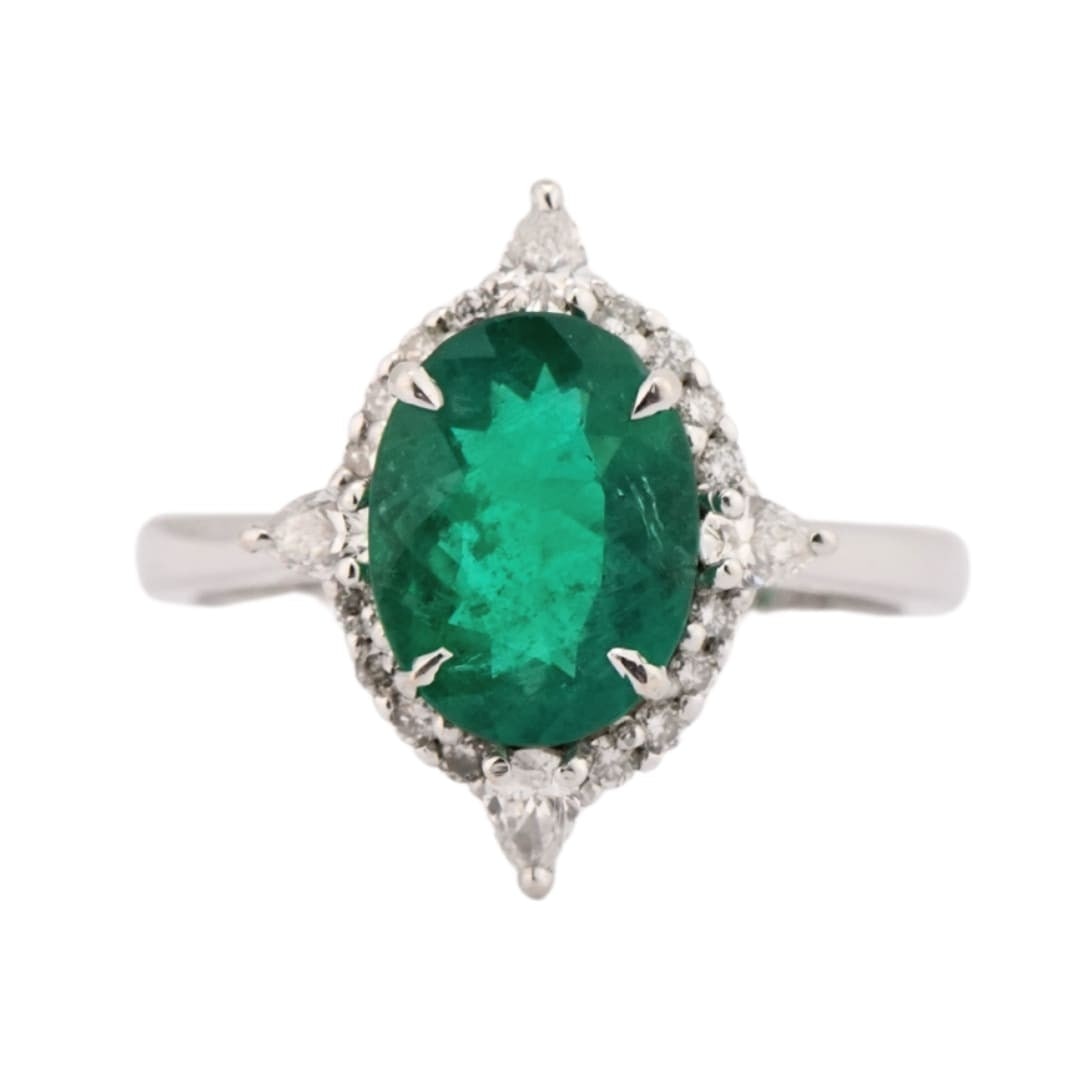 Unbranded Oval Natural Emerald Diamond Ring in 18K White Gold: Unbranded Oval Natural Emerald Diamond Ring in 18K White Gold Well-crafted pre-owned ring featuring a natural oval emerald accented by round brilliant and pear shape diamonds. The ring is stamped 18K 