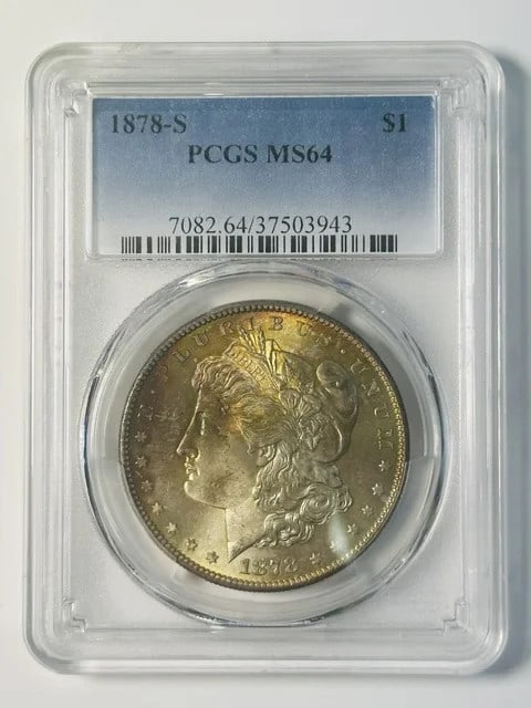 PCGS MS-64 1878-S Morgan Dollar Silver Rainbow Toning: PCGS MS-64 1878-S Morgan Dollar Silver Rainbow Toning 1878-S Morgan Silver Dollar certified by PCGS as MS-64, featuring rainbow toning. This pre-owned coin is composed of silver and carries a dollar d